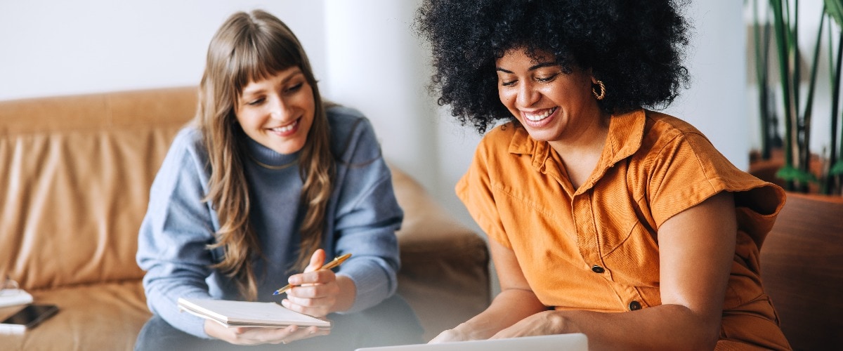 Happy young businesswomen having an online meeting in a lobby