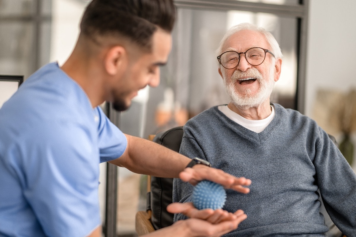 Patient having his hand massaged with a spiky massage ball