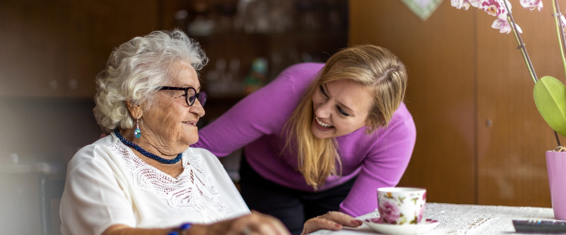 Young woman spending time with her elderly grandmother at home